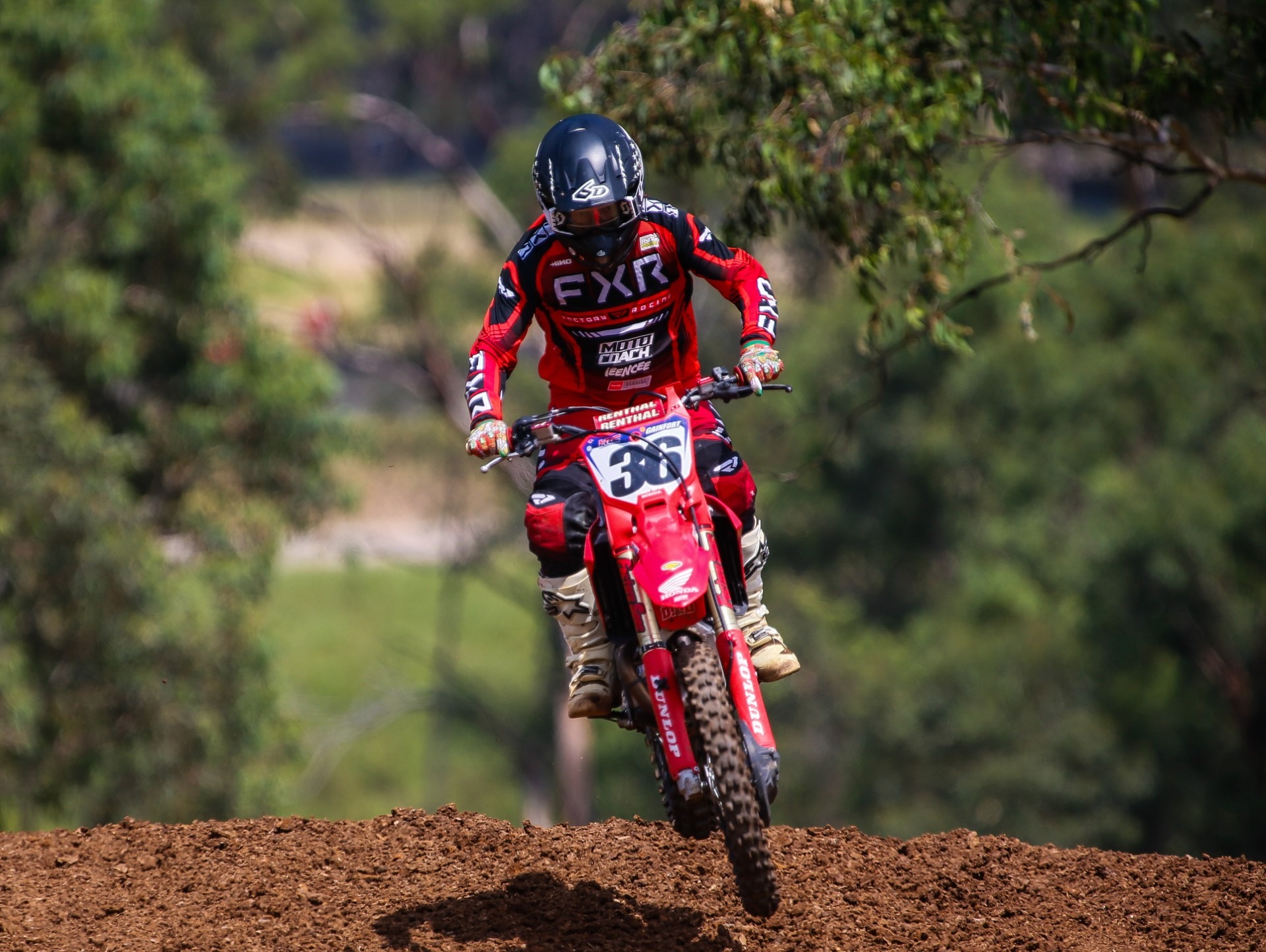 Moto Coach motocross rider clearing rhythm section during training
